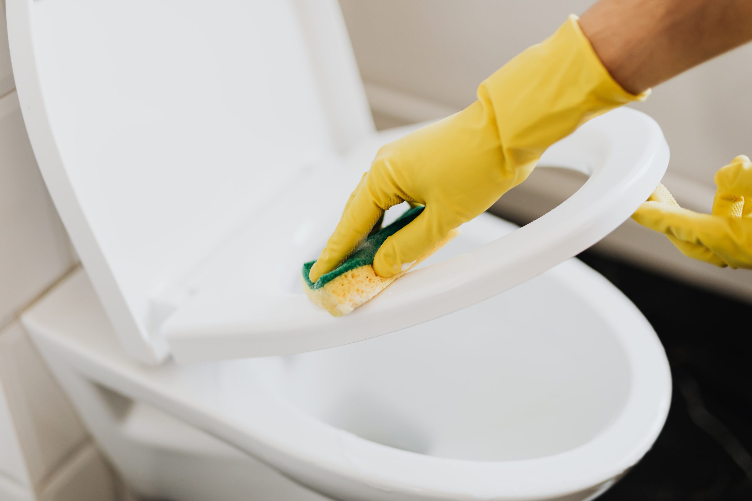 Nettoyage siège toilettes avec éponge et gants jaunes