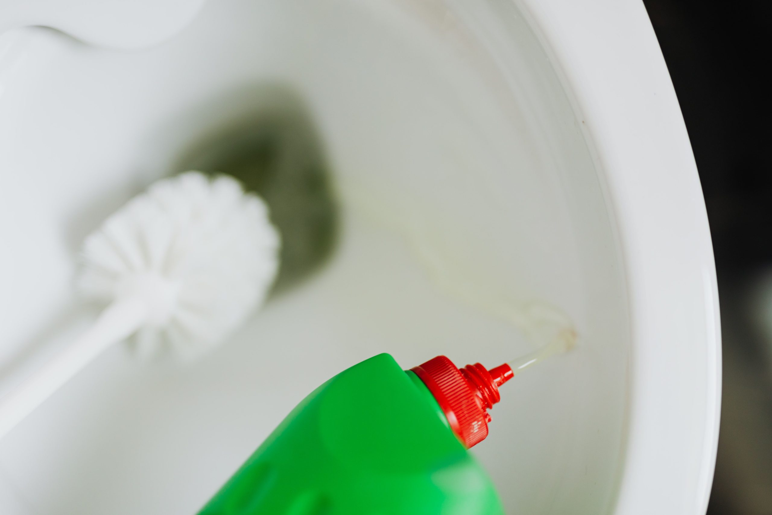 Détergent versé dans cuvette avec brosse de toilettes